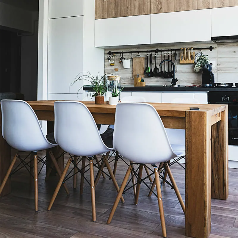 木製ダイニングテーブルと白いチェアが並ぶモダンなキッチンダイニング空間
