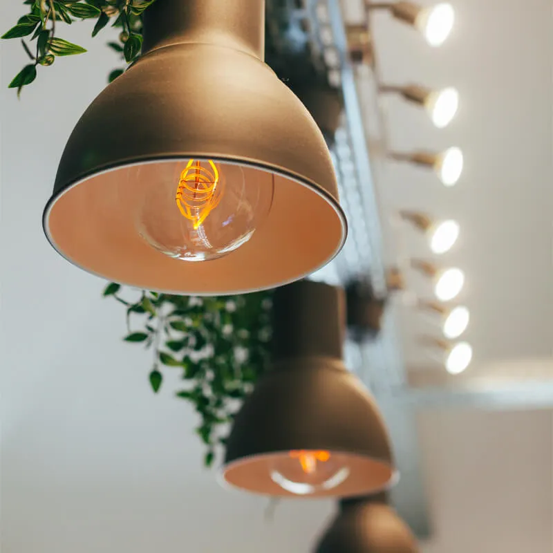 エジソン電球が使われた黒いペンダントライトと背景のスポットライト